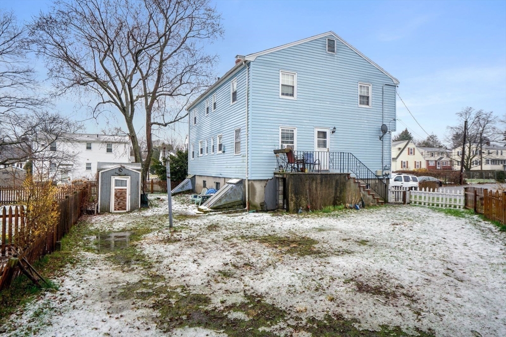 10-12 Norcross Circle Arlington, MA 02474 - Photo 22 of 31 a view of a house with a yard covered in snow