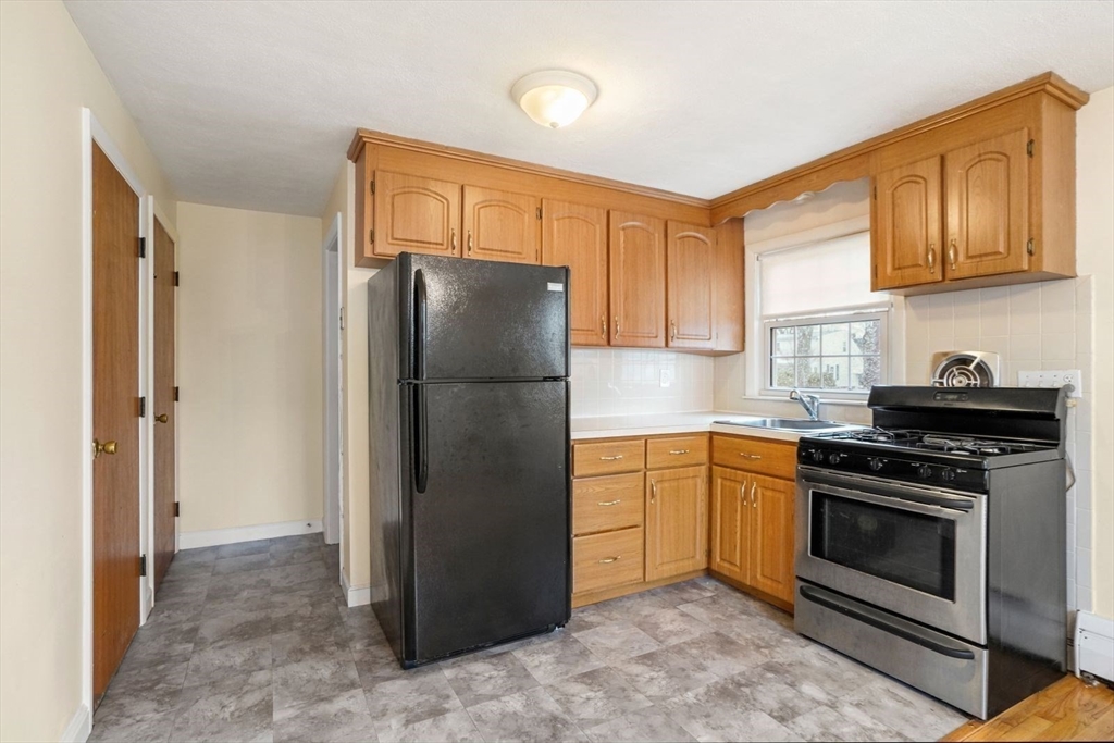 10-12 Norcross Circle Arlington, MA 02474 - Photo 7 of 31 a kitchen with stainless steel appliances granite countertop a refrigerator stove and sink