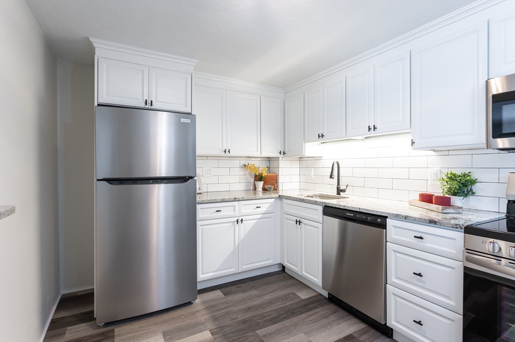 9 Broadway, Unit 223 Saugus, MA 01906 - Photo 2 of 18 a kitchen with white cabinets and white appliances