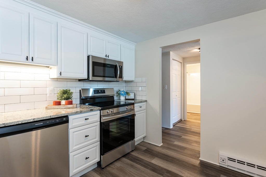 9 Broadway, Unit 223 Saugus, MA 01906 - Photo 3 of 18 a kitchen with stainless steel appliances granite countertop a stove a sink and a microwave