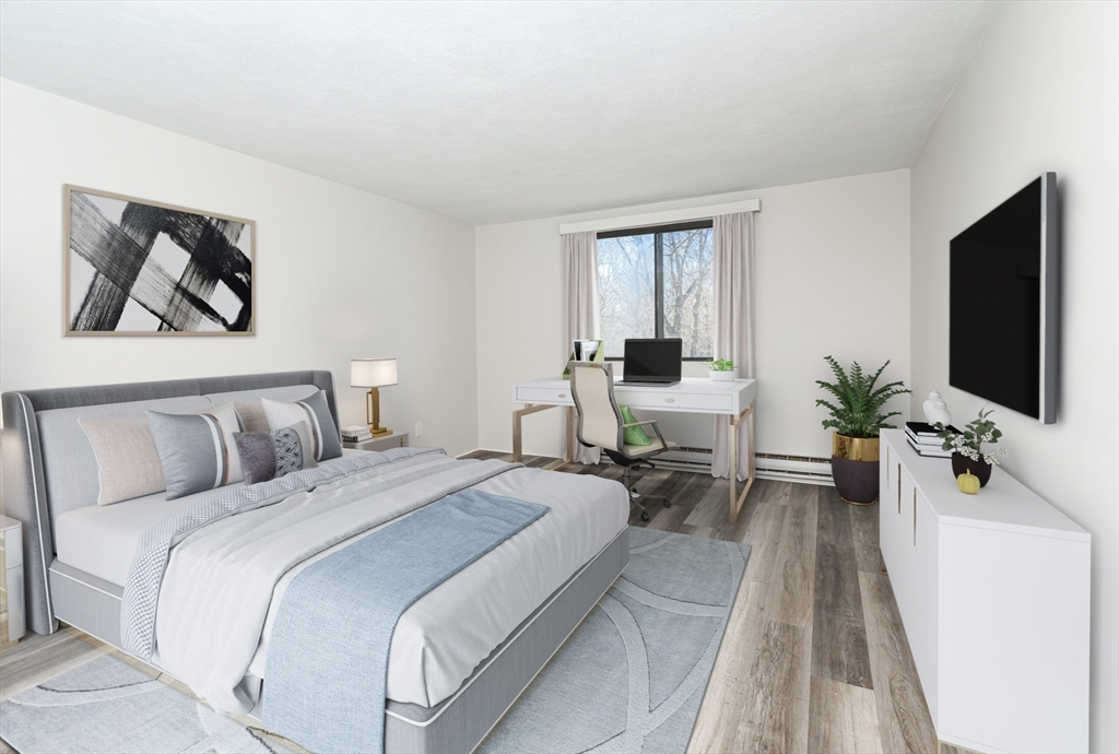 9 Broadway, Unit 223 Saugus, MA 01906 - Photo 4 of 18 a bedroom with a bed and a flat screen tv