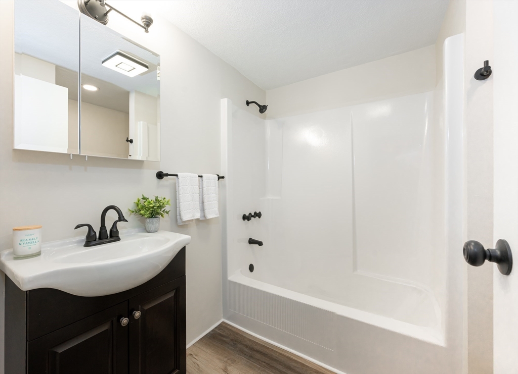 9 Broadway, Unit 223 Saugus, MA 01906 - Photo 6 of 18 a bathroom with a bathtub a sink a mirror and shower