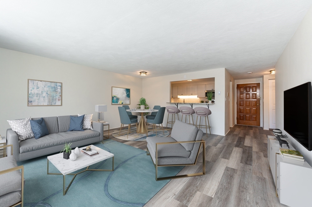 9 Broadway, Unit 223 Saugus, MA 01906 - Photo 8 of 18 a living room with furniture and a flat screen tv