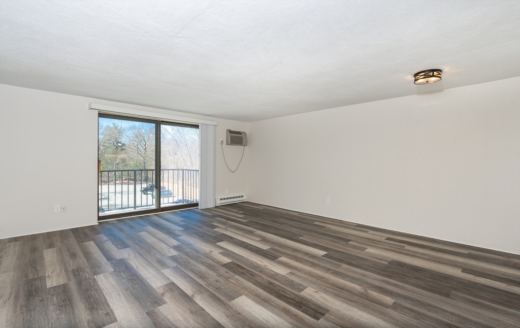 9 Broadway, Unit 223 Saugus, MA 01906 - Photo 9 of 18 a view of an empty room with wooden floor and a window