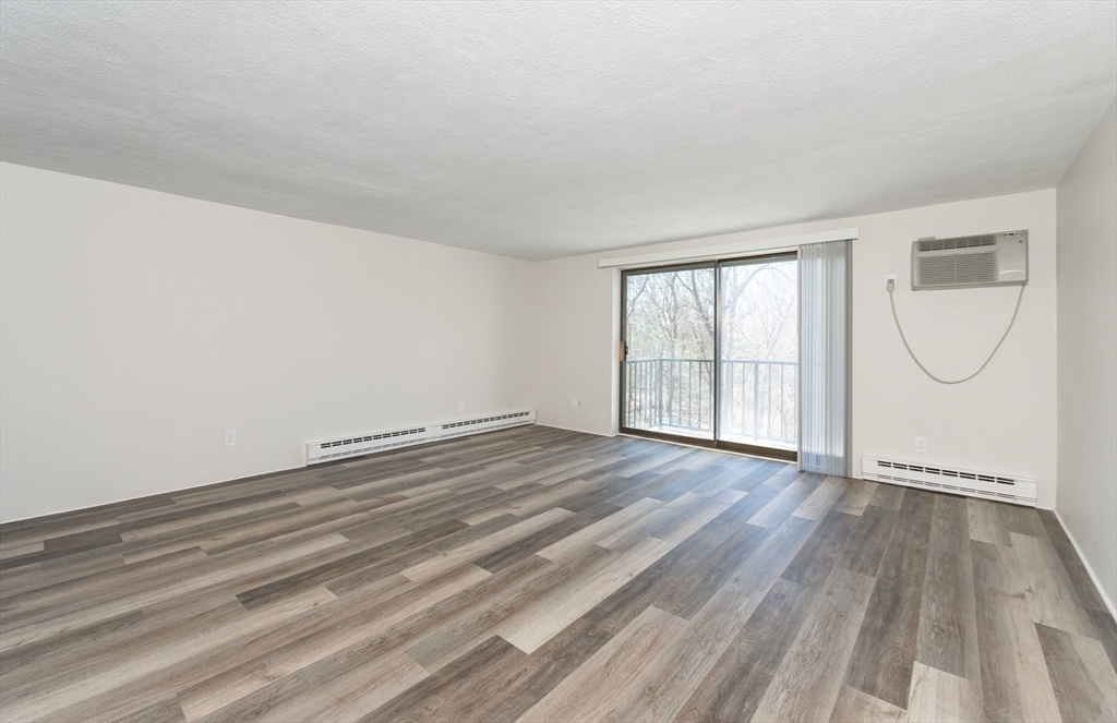 9 Broadway, Unit 223 Saugus, MA 01906 - Photo 10 of 18 a view of empty room with wooden floor and fan