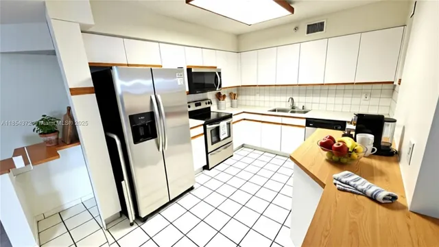 a kitchen with stainless steel appliances a refrigerator sink and microwave