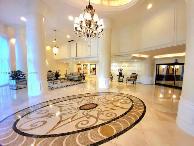 a lobby with furniture and a chandelier