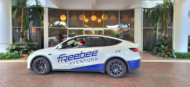 a view of a car door of the house and a yard