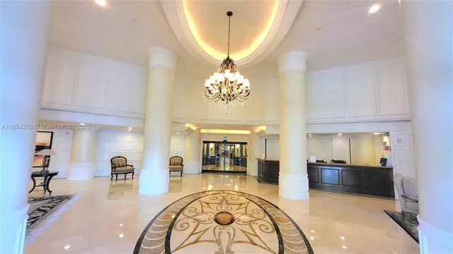 a lobby with furniture and a chandelier