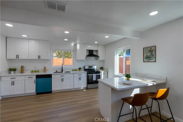 a kitchen with stainless steel appliances kitchen island granite countertop a sink and cabinets