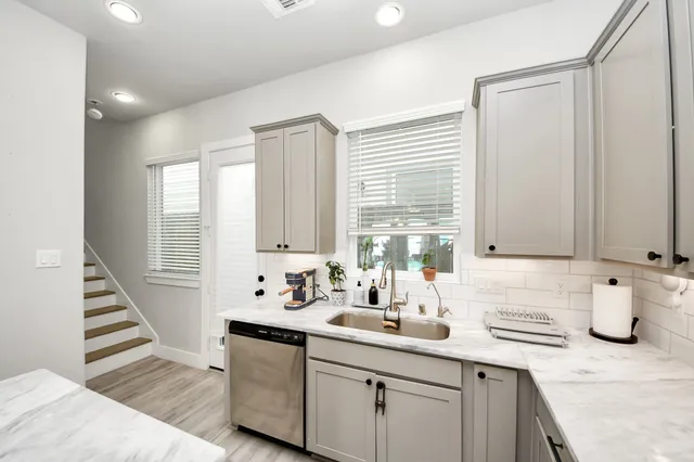 a kitchen with sink a window and cabinets