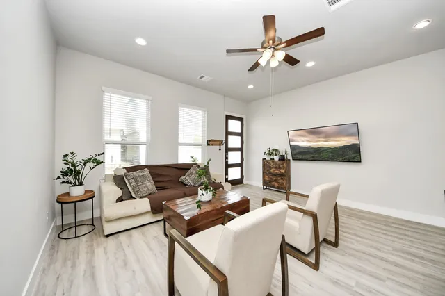 a living room with furniture and a wooden floor