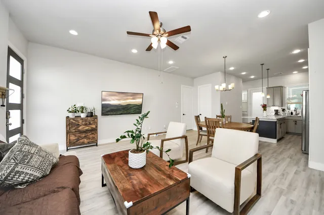 a living room with furniture and a view of kitchen
