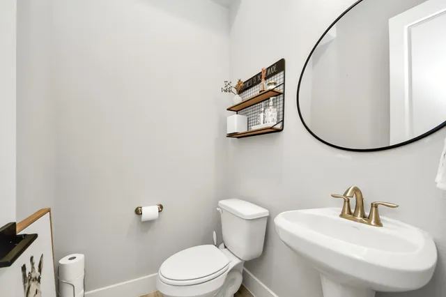 a bathroom with a toilet a sink and mirror
