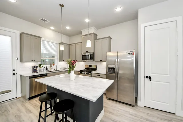 a kitchen with refrigerator cabinets dining table and chairs