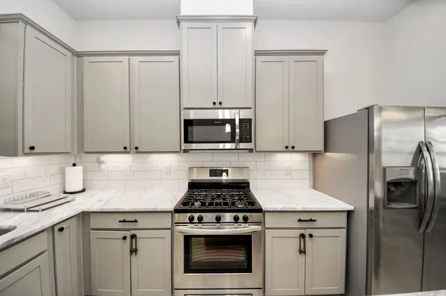 a kitchen with cabinets stainless steel appliances and a sink