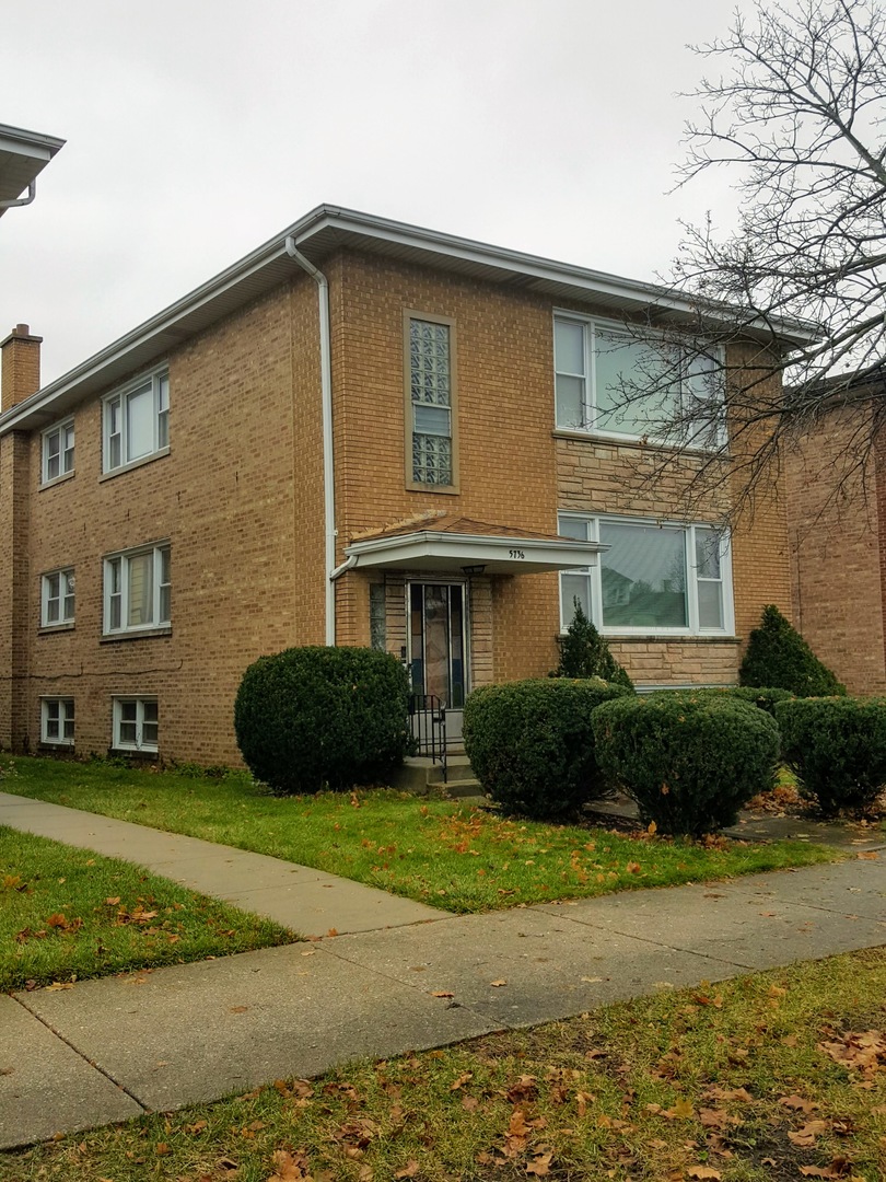 5736 West Gunnison Street, Unit 2 Chicago, IL 60630 - Photo 2 of 17 a front view of a house with a yard