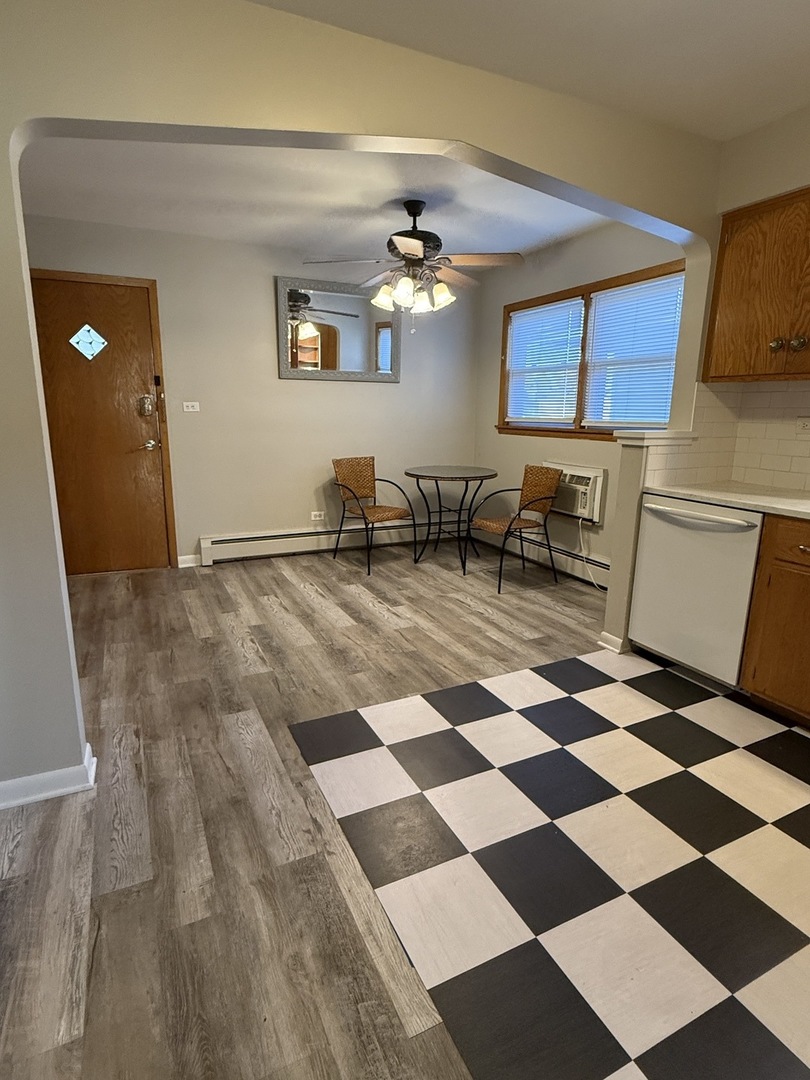 5736 West Gunnison Street, Unit 2 Chicago, IL 60630 - Photo 3 of 17 a living room with a black white checkered floor with a gaming machine and dining chairs