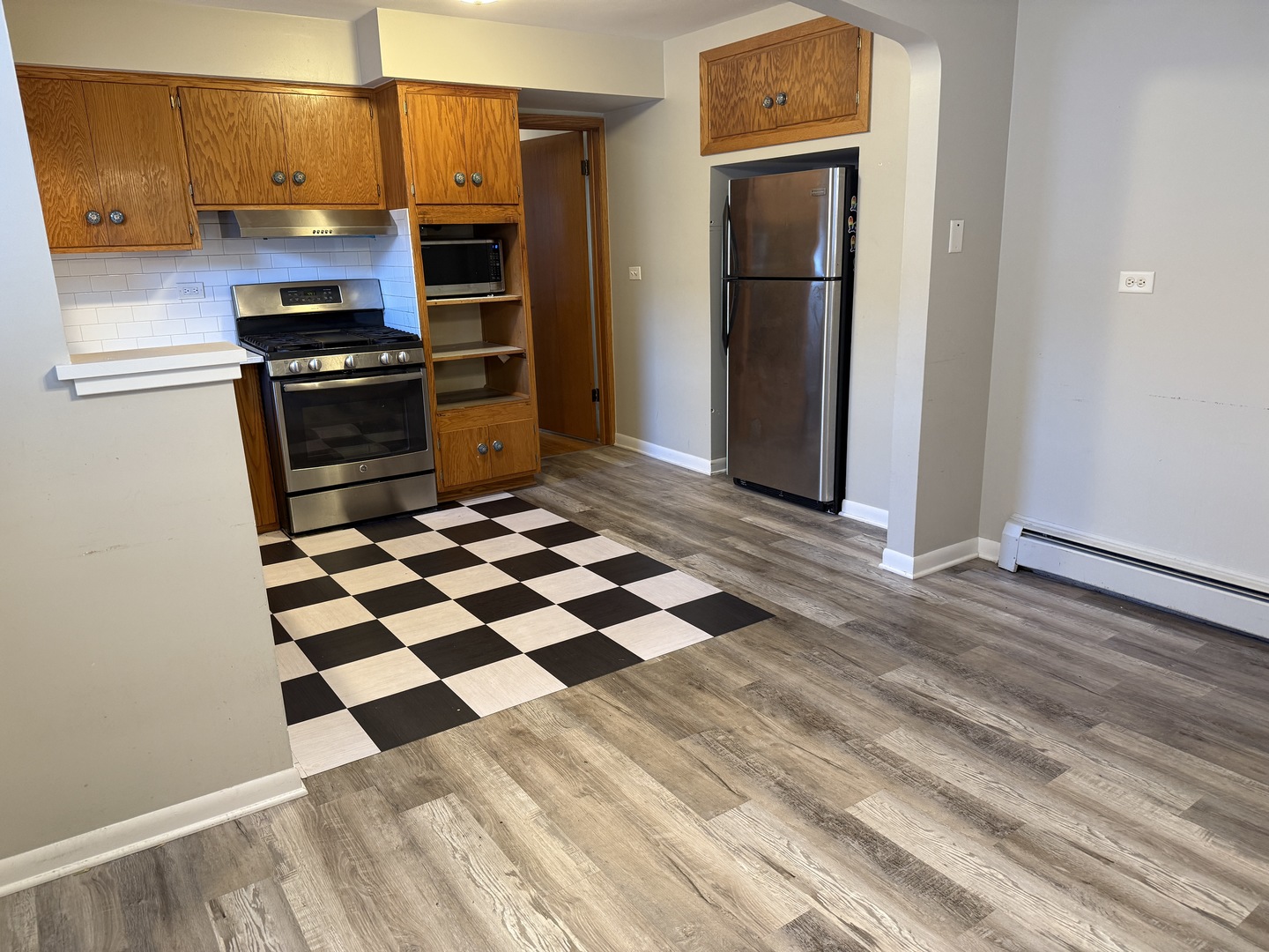 5736 West Gunnison Street, Unit 2 Chicago, IL 60630 - Photo 6 of 17 a kitchen with granite countertop stainless steel appliances and wooden floor
