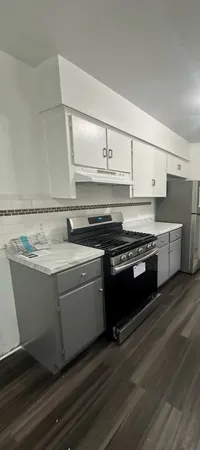 a view of kitchen with stainless steel appliances granite countertop a stove and a sink