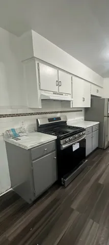 a view of kitchen with stainless steel appliances granite countertop a stove and a sink