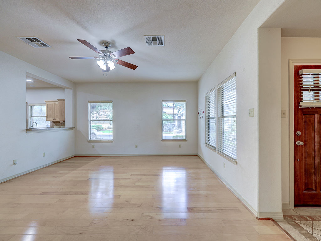9707 Anderson Mill Road, Unit 22 Austin, TX 78750 - Photo 11 of 39 Blonde wood flooring and an open-concept layout create an airy living space, welcoming abundant natural light.