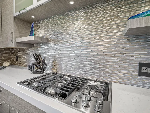 a kitchen with a sink dishwasher and white cabinets with wooden floor