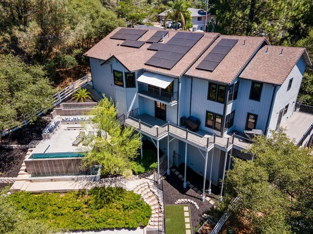 an aerial view of a house with a yard and potted plants