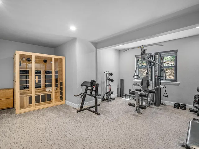 a living room with furniture gym equipment and a large window