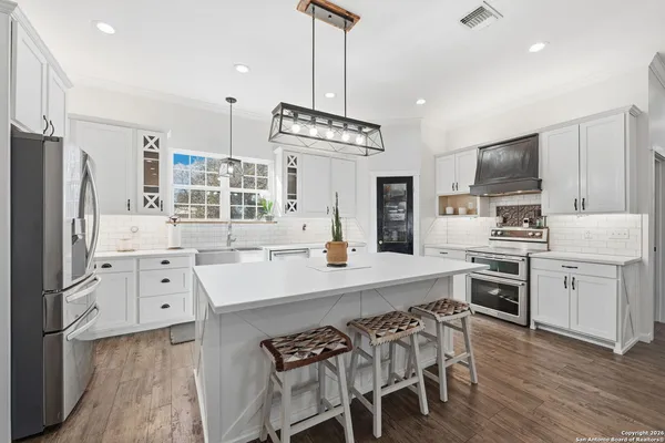 a dining room with stainless steel appliances a dining table chairs and kitchen view