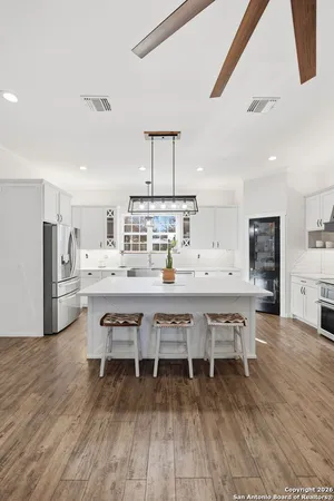 a kitchen with stainless steel appliances a stove and white cabinets