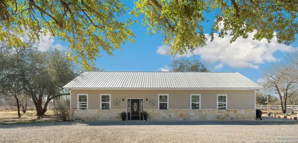 a front view of a house with a tree