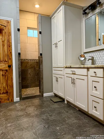 a bathroom with a shower sink and mirror