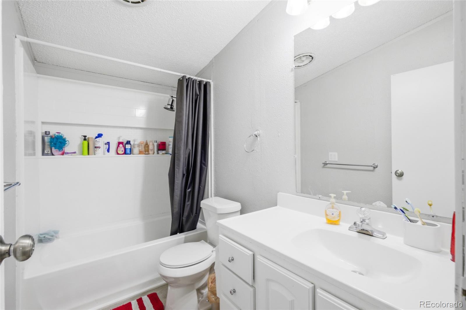 1724 Clark Street Aurora, CO 80011 - Photo 13 of 19 a bathroom with a sink a toilet and a mirror