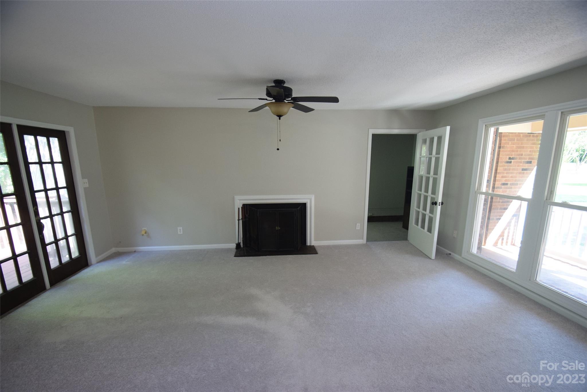 8429 Fieldwood Road Mint Hill, NC 28227 - Photo 11 of 28 an empty room with chandelier fan and windows