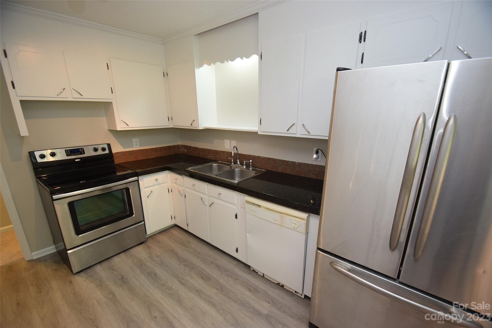 8429 Fieldwood Road Mint Hill, NC 28227 - Photo 16 of 28 a kitchen with granite countertop white cabinets and white appliances