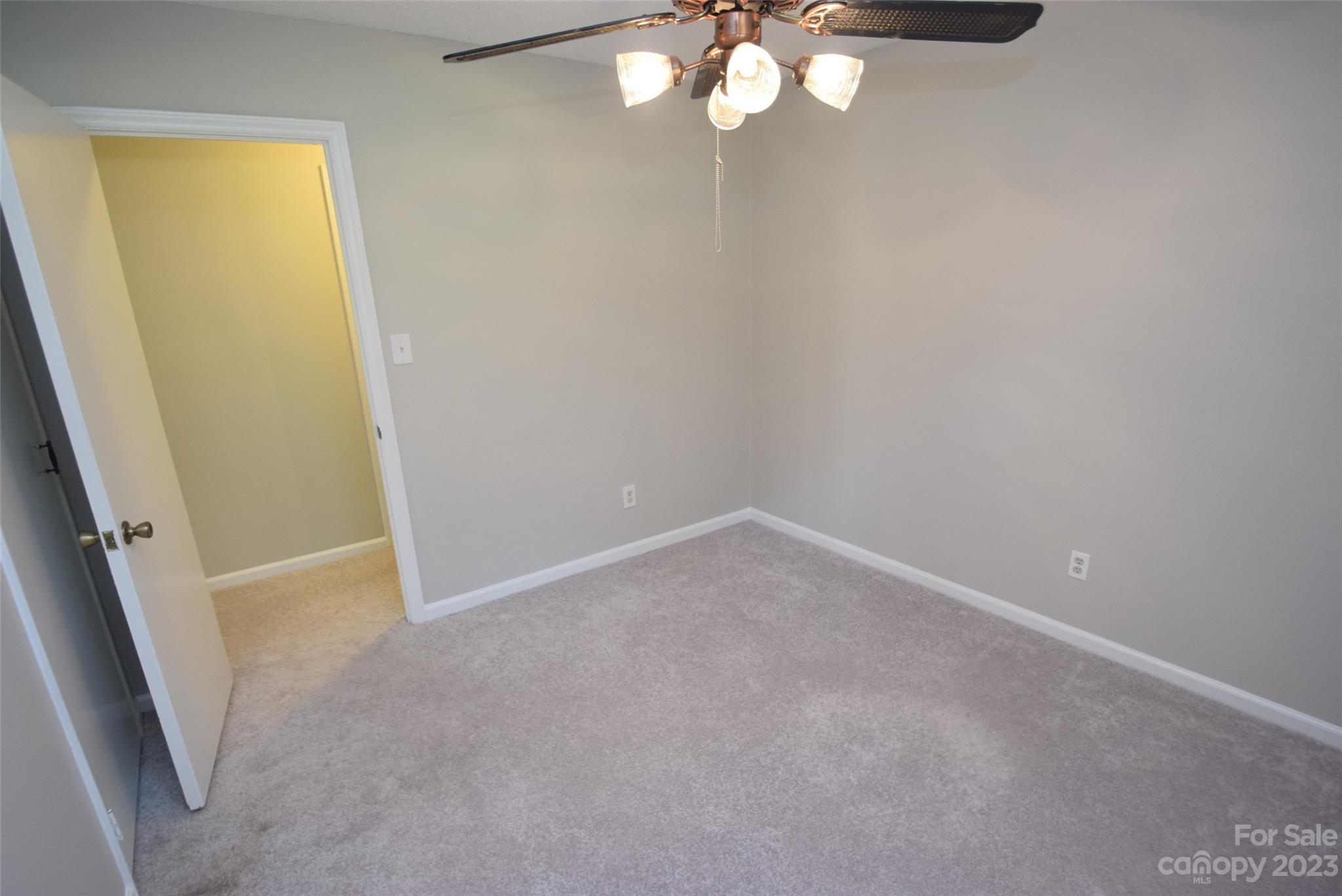 8429 Fieldwood Road Mint Hill, NC 28227 - Photo 27 of 28 an empty room with a chandelier fan and wooden floor