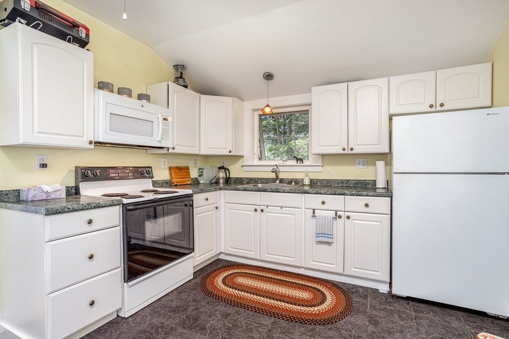 27 Hay Road Ashburnham, MA 01430 - Photo 23 of 42 a kitchen with granite countertop a sink stainless steel appliances and white cabinets