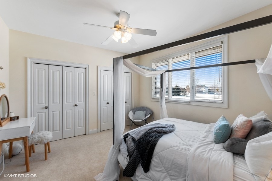 24042 Old Farm Road Manhattan, IL 60442 - Photo 19 of 32 a bedroom with a bed and a chandelier