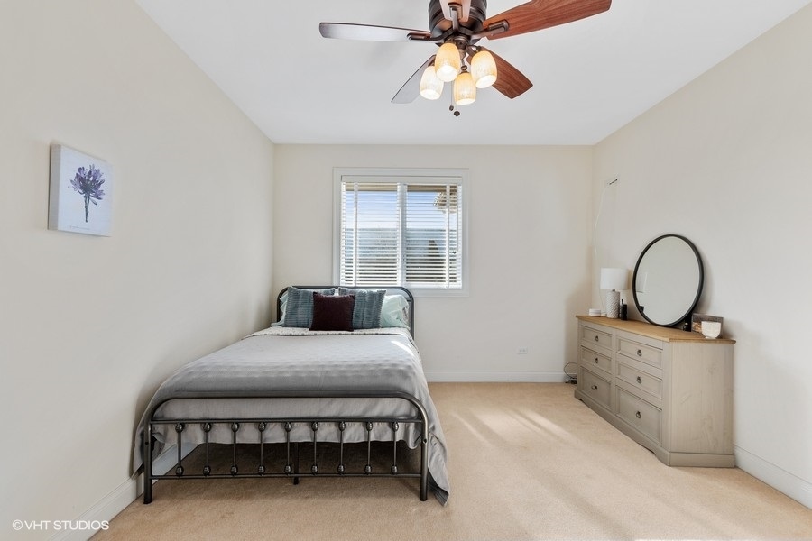 24042 Old Farm Road Manhattan, IL 60442 - Photo 21 of 32 a bedroom with a bed and a chandelier