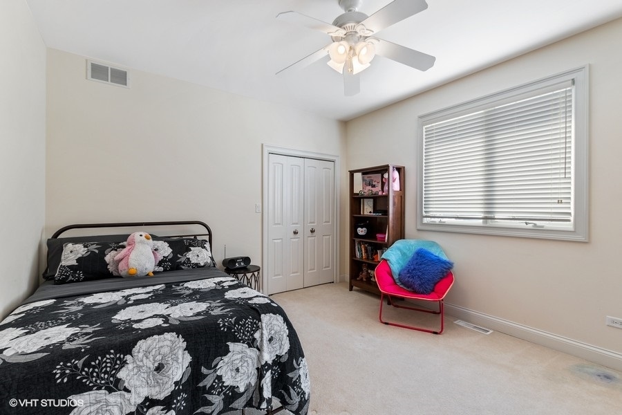 24042 Old Farm Road Manhattan, IL 60442 - Photo 23 of 32 a bedroom with a bed and a chandelier