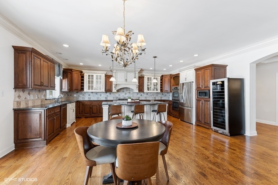 24042 Old Farm Road Manhattan, IL 60442 - Photo 7 of 32 a kitchen with stainless steel appliances granite countertop a kitchen island a stove a table and chairs in it