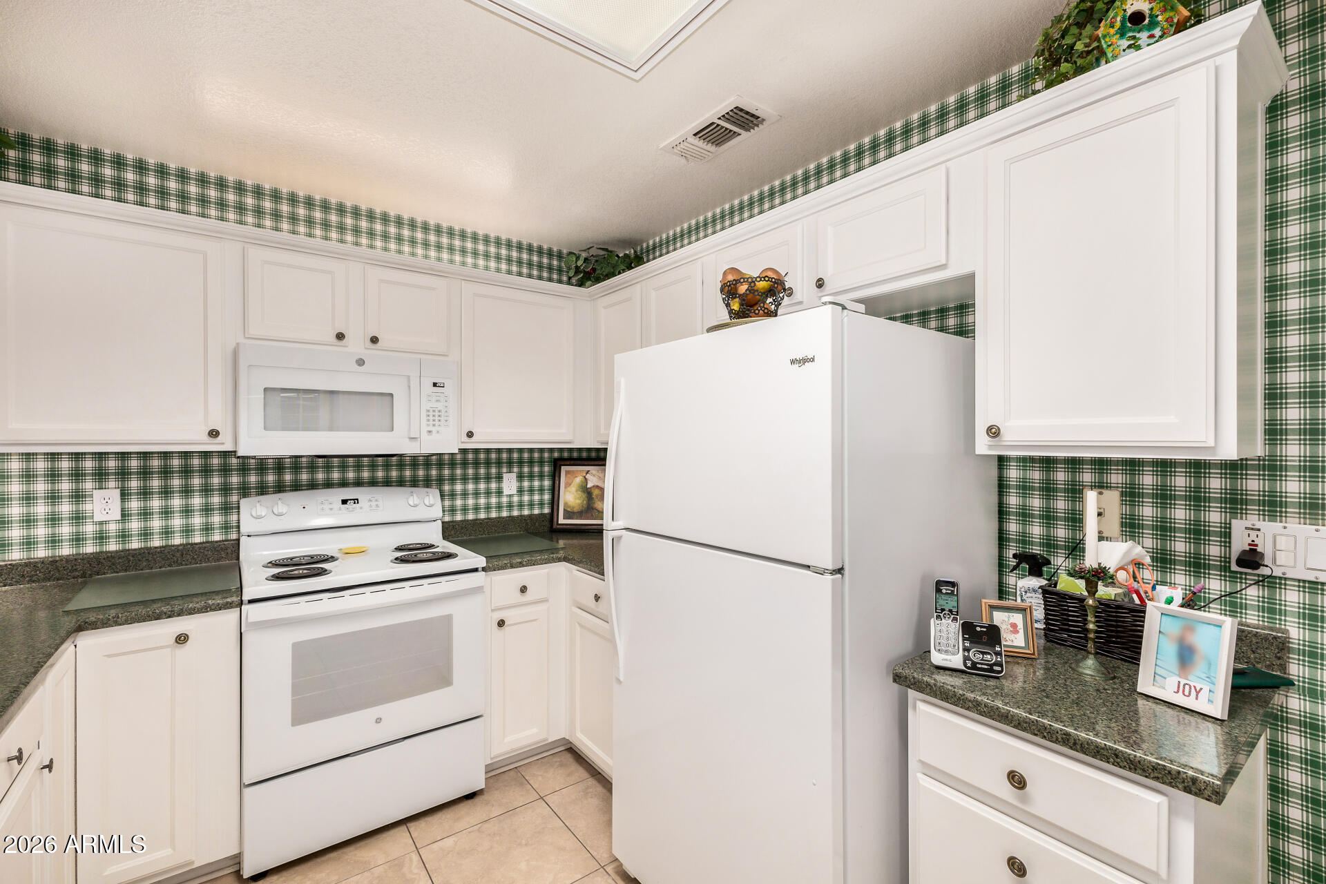 8508 West Utopia Road Peoria, AZ 85382 - Photo 13 of 28 a kitchen with refrigerator a stove a sink and white cabinets