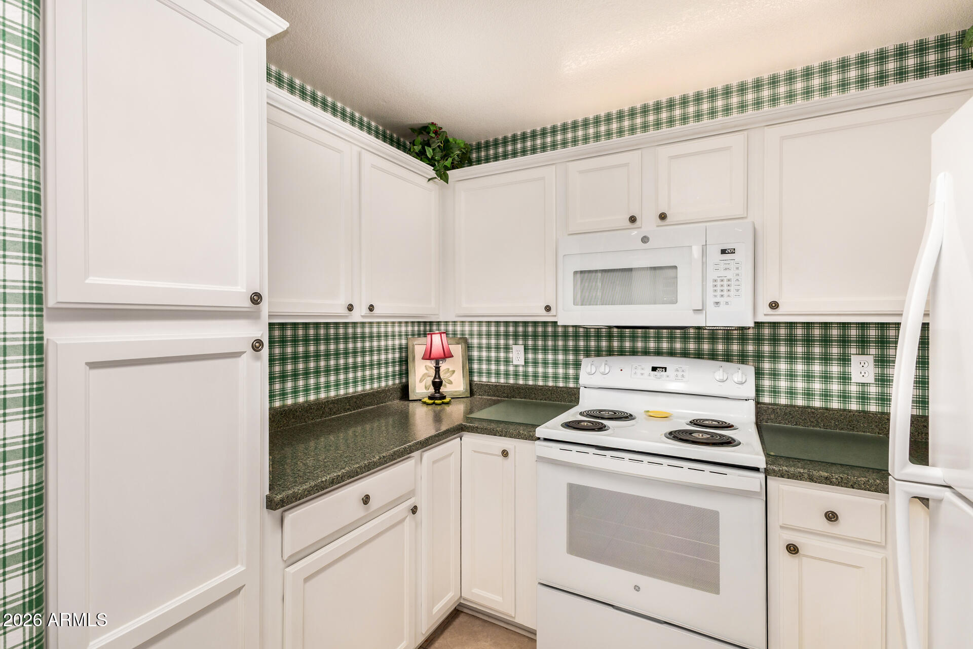 8508 West Utopia Road Peoria, AZ 85382 - Photo 14 of 28 a kitchen with a stove and white cabinets