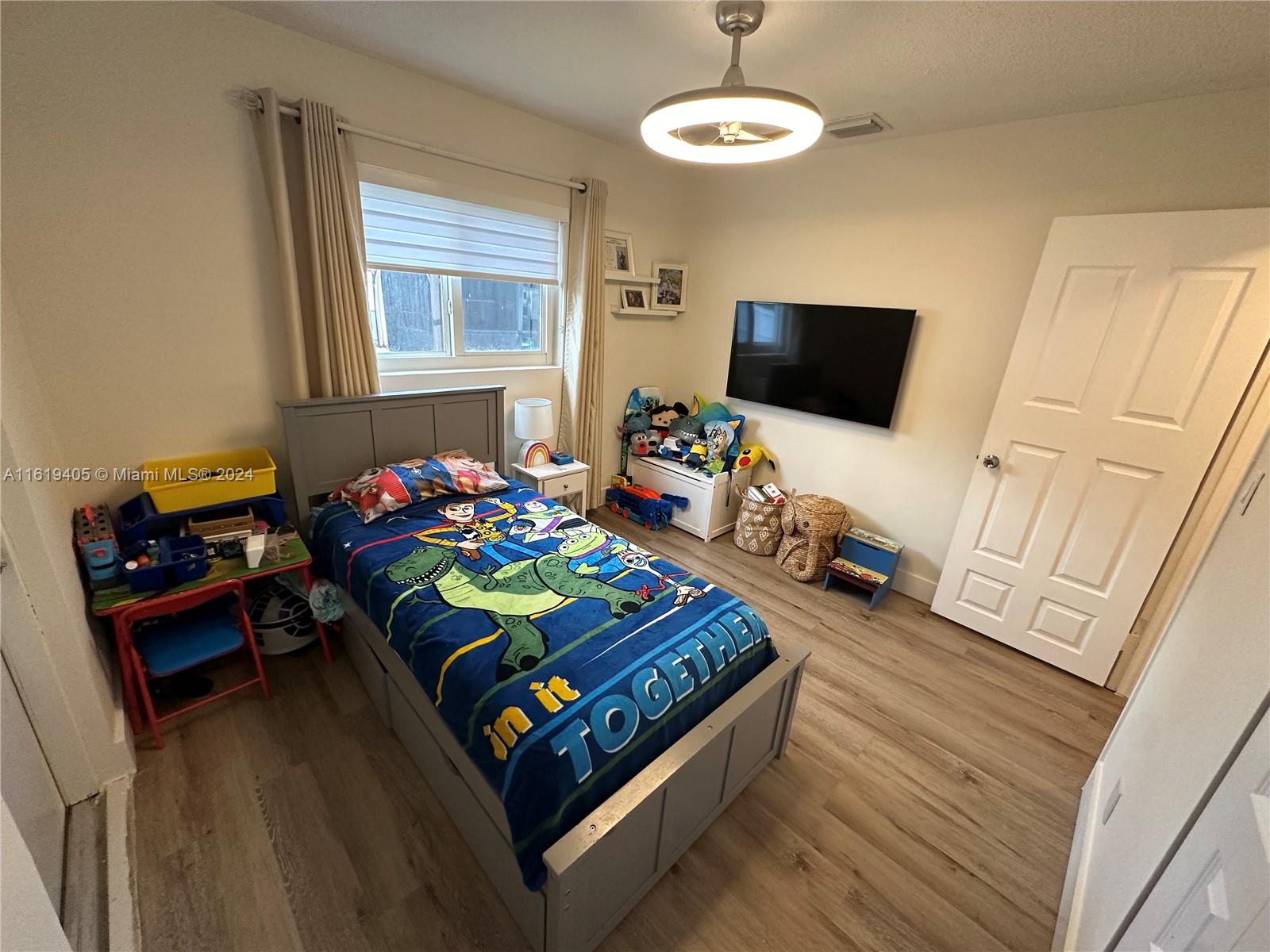 6791 Pershing Street Hollywood, FL 33024 - Photo 19 of 31 a bedroom with a bed and a flat screen tv