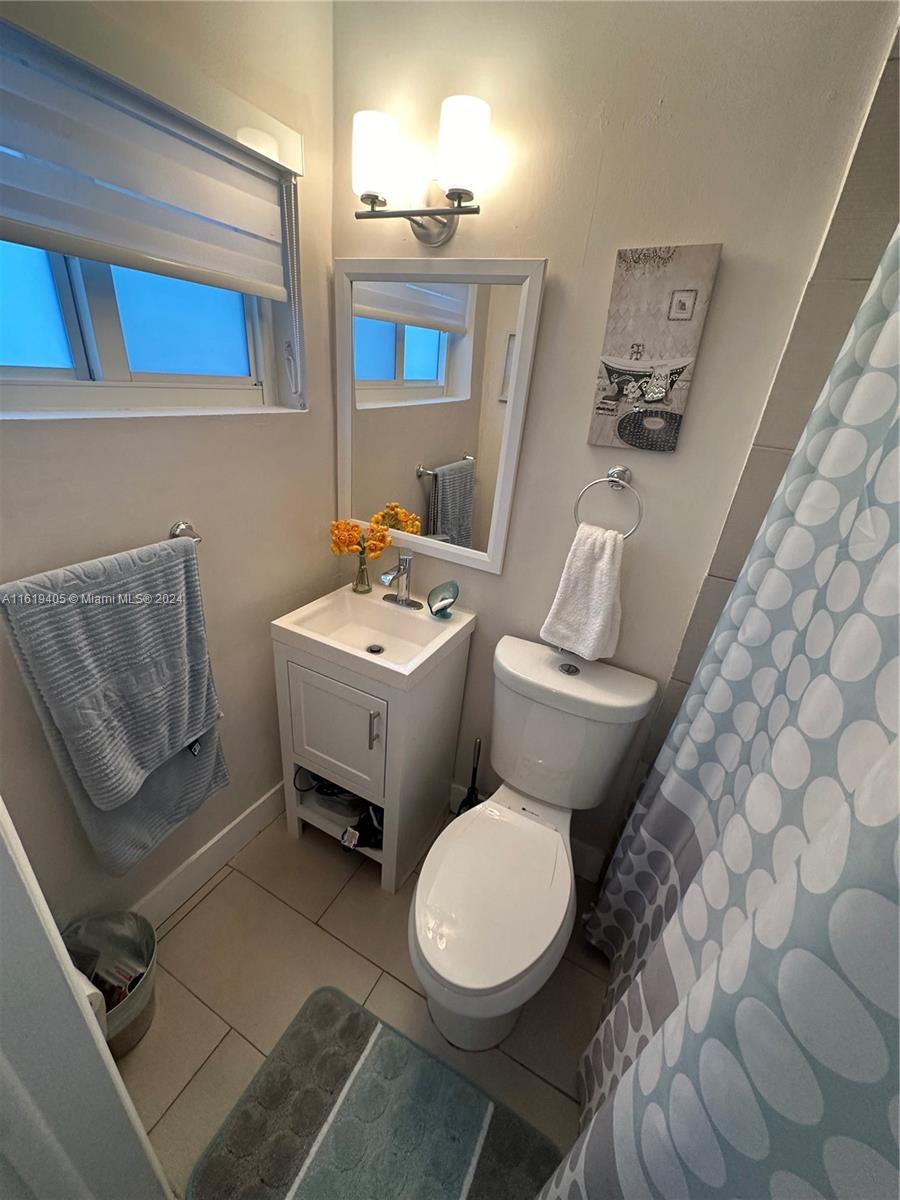 6791 Pershing Street Hollywood, FL 33024 - Photo 22 of 31 a white toilet sitting next to a bathroom sink