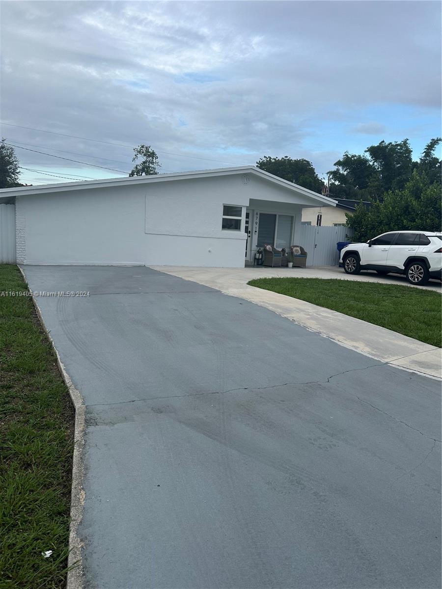 6791 Pershing Street Hollywood, FL 33024 - Photo 25 of 31 a front view of a house with a garden and parking