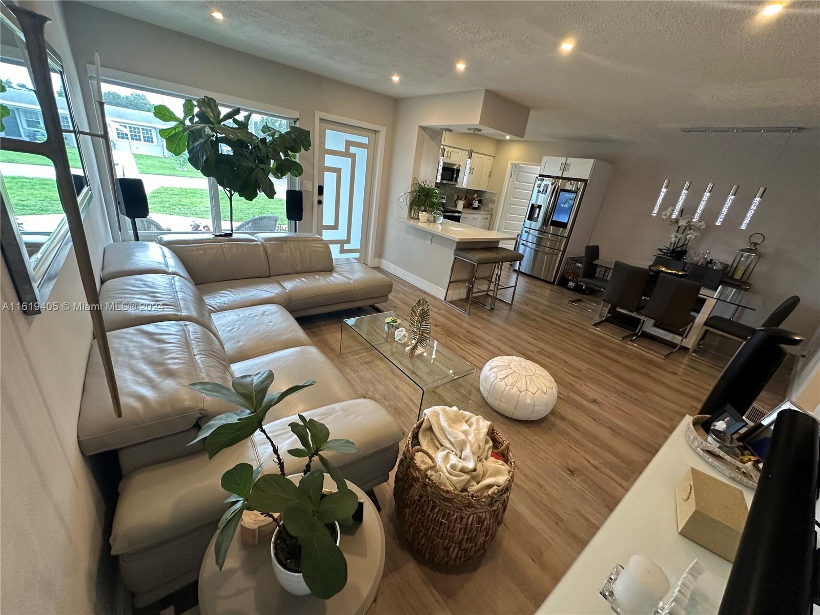 6791 Pershing Street Hollywood, FL 33024 - Photo 3 of 31 a living room with furniture and a floor to ceiling window