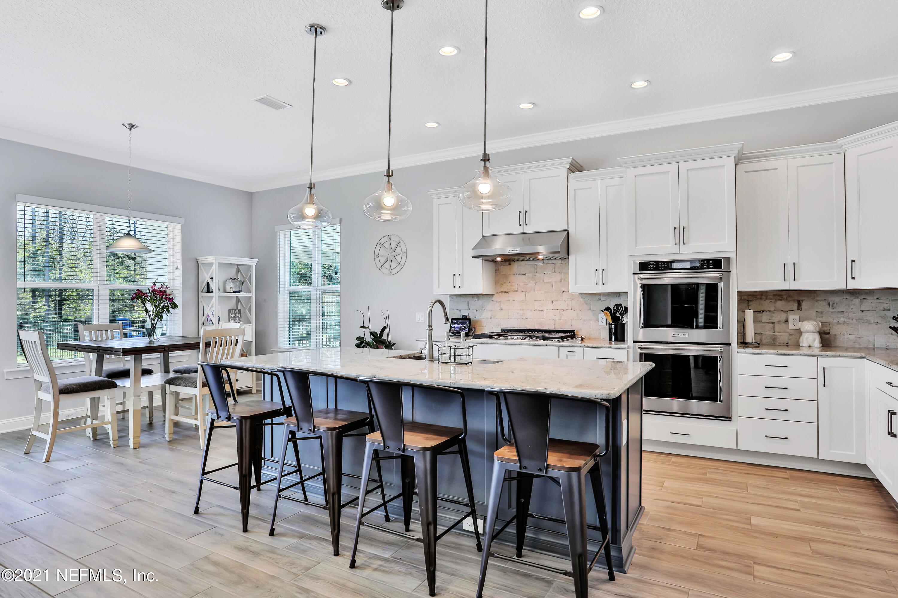 140 Pine Haven Drive St. Johns, FL 32259 - Photo 8 of 66 a kitchen with stainless steel appliances kitchen island granite countertop a table chairs and a view of living room