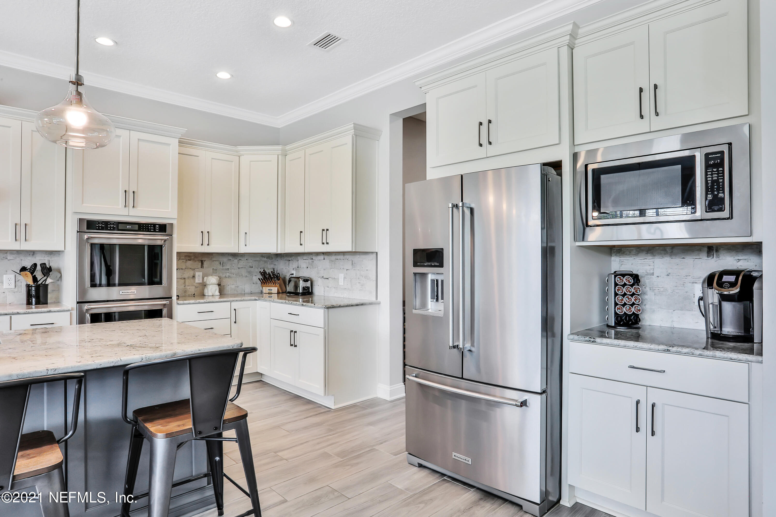 140 Pine Haven Drive St. Johns, FL 32259 - Photo 9 of 66 a kitchen with white cabinets stainless steel appliances and a center island